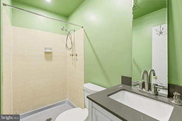 a bathroom with a granite countertop sink toilet and shower