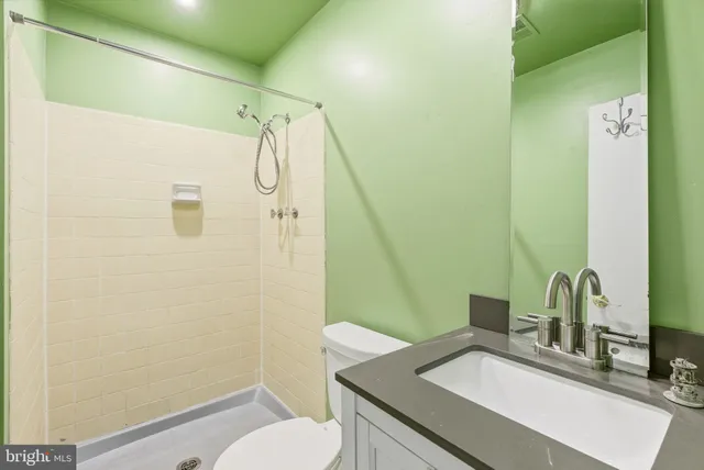 a bathroom with a granite countertop sink toilet and shower