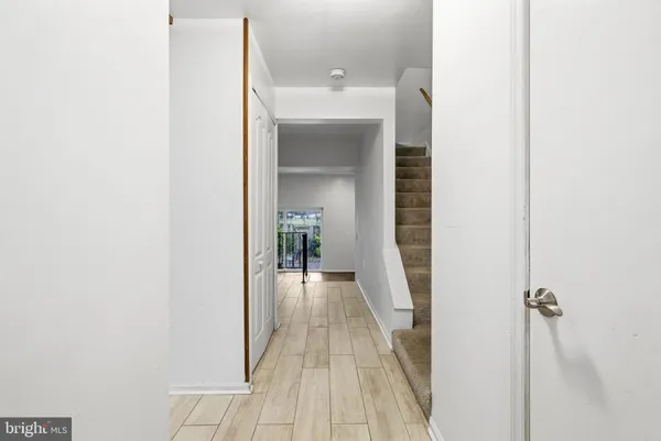 a view of a hallway with wooden floor and staircase
