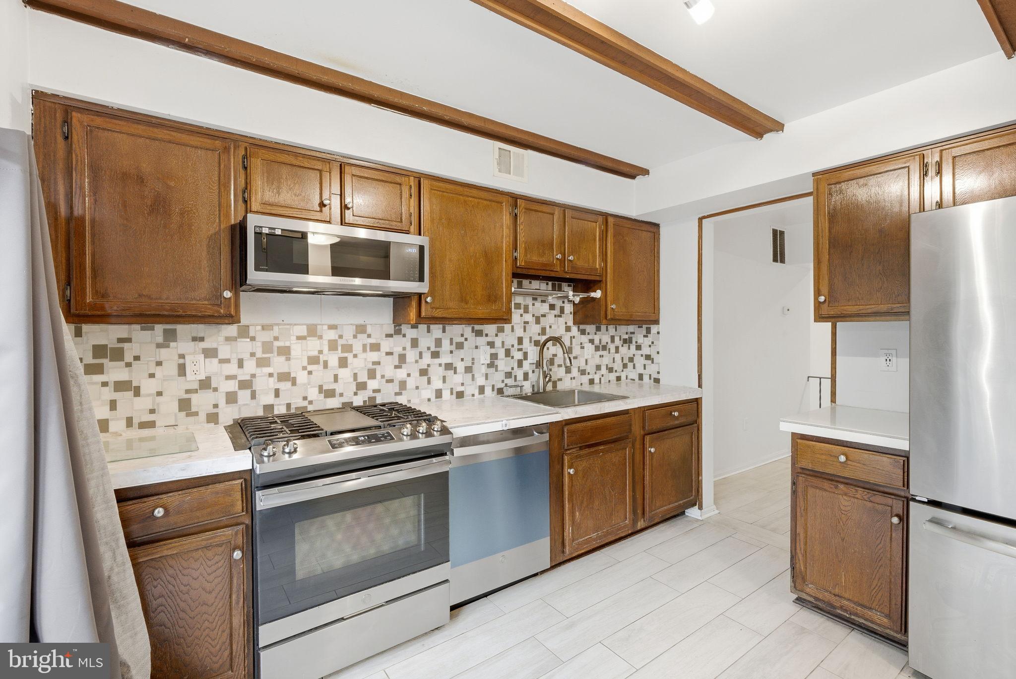 11072 Berrypick Lane Columbia, MD 21044 - Photo 5 of 35 a kitchen with stainless steel appliances granite countertop a stove a microwave and a refrigerator