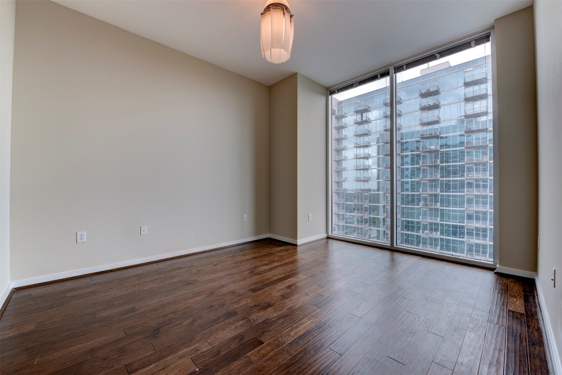 5925 Almeda Road, Unit 2214 Houston, TX 77004 - Photo 14 of 34 a view of an empty room with wooden floor and a window