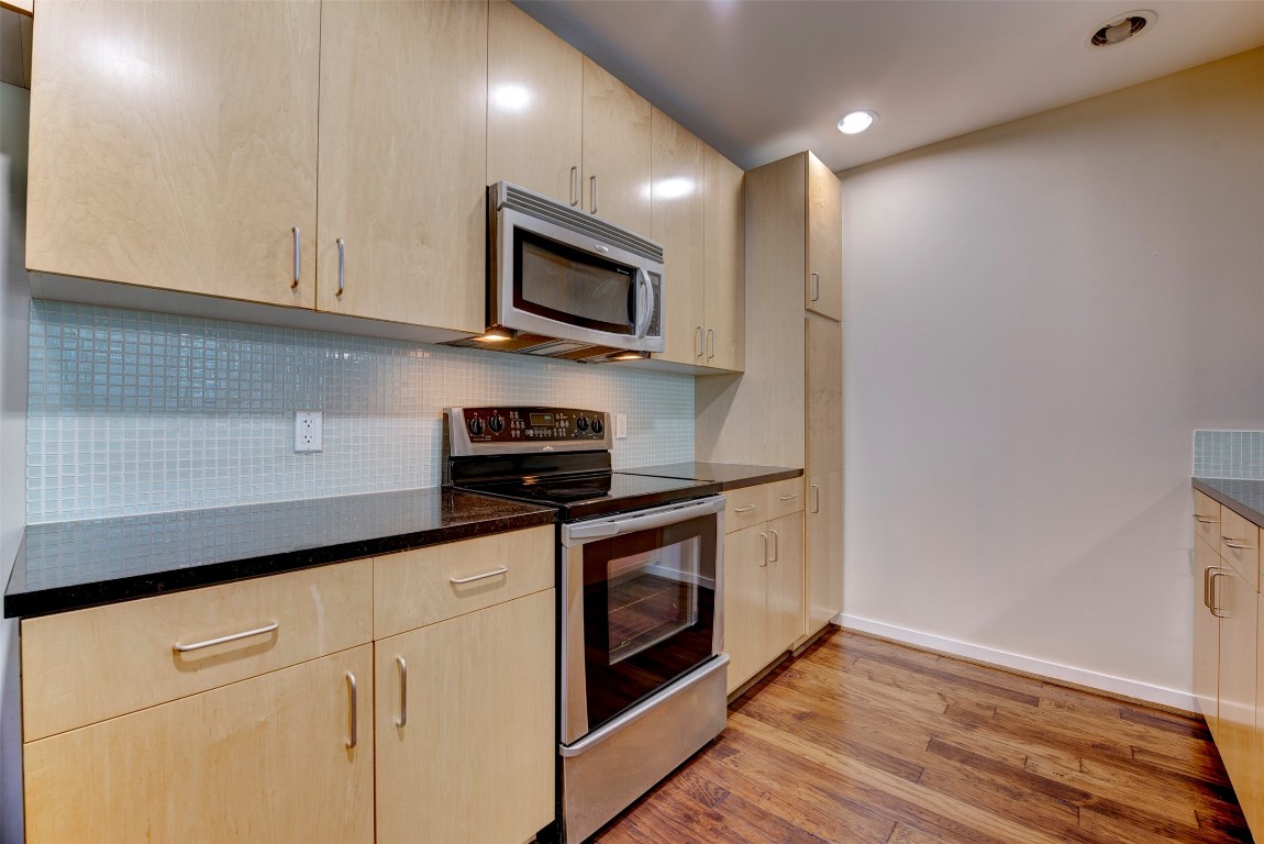 5925 Almeda Road, Unit 2214 Houston, TX 77004 - Photo 3 of 34 a kitchen with stainless steel appliances granite countertop white cabinets a microwave a sink and a refrigerator