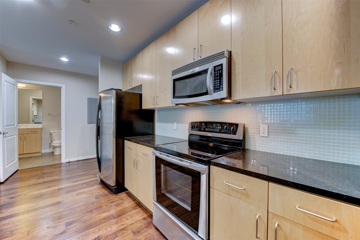 5925 Almeda Road, Unit 2214 Houston, TX 77004 - Photo 6 of 34 a kitchen with stainless steel appliances granite countertop a refrigerator stove and microwave