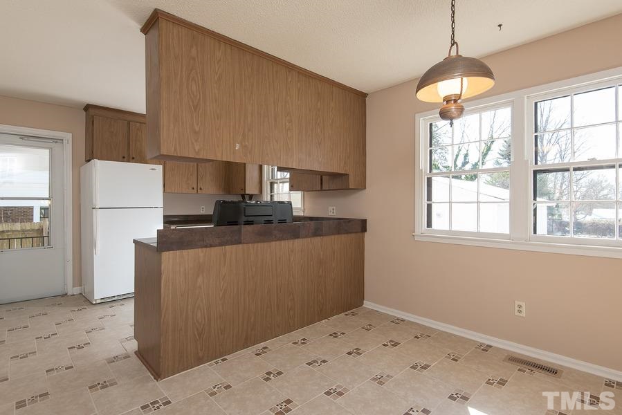 4120 Live Oak Road Raleigh, NC 27604 - Photo 7 of 25 a kitchen with kitchen island a sink a stove a refrigerator and a window
