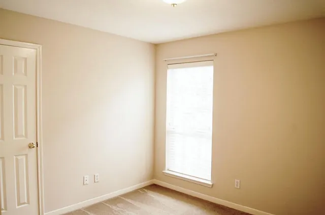 a view of a small space with wooden floor and a window