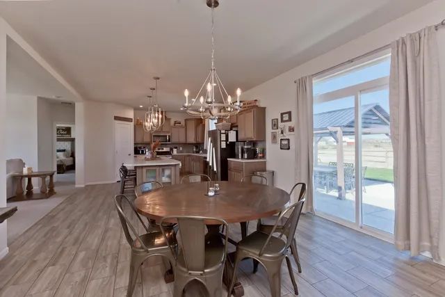 a dining room with furniture a chandelier and wooden floor