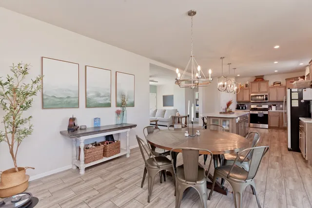 a dining room with furniture a chandelier and wooden floor