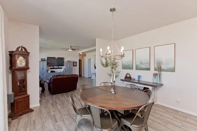 a view of a dining room with furniture wooden floor kitchen and chandelier