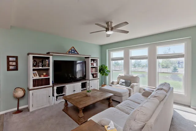 a living room with furniture a window and a flat screen tv