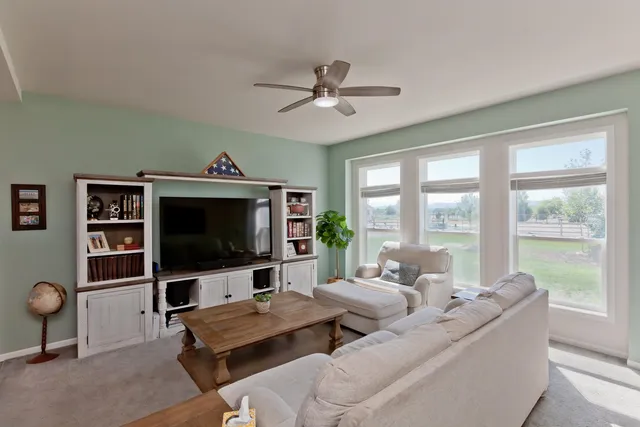 a living room with furniture a large window and a flat screen tv