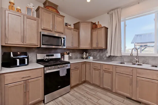 a kitchen with stainless steel appliances granite countertop a sink stove and microwave