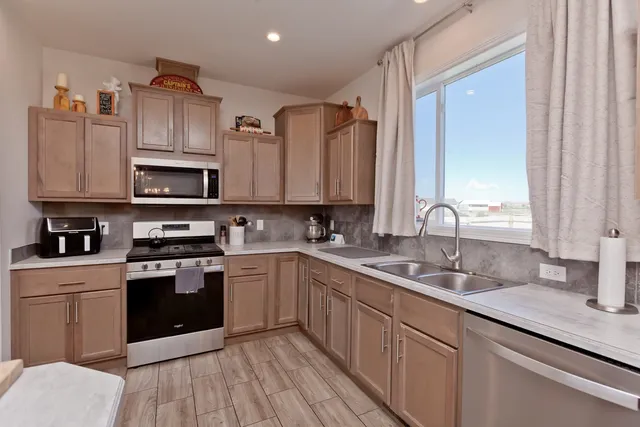 a kitchen with stainless steel appliances granite countertop a sink stove and refrigerator