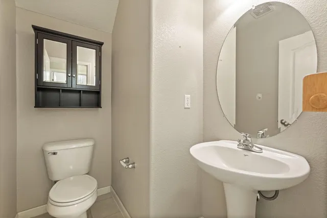 a bathroom with a toilet a sink and mirror