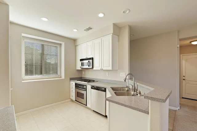 a kitchen that has a sink a stove and window