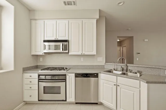 a kitchen with white cabinets and white appliances
