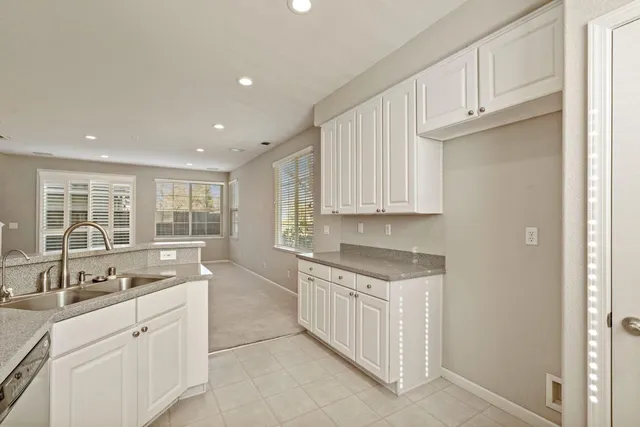a large white kitchen with granite countertop a sink