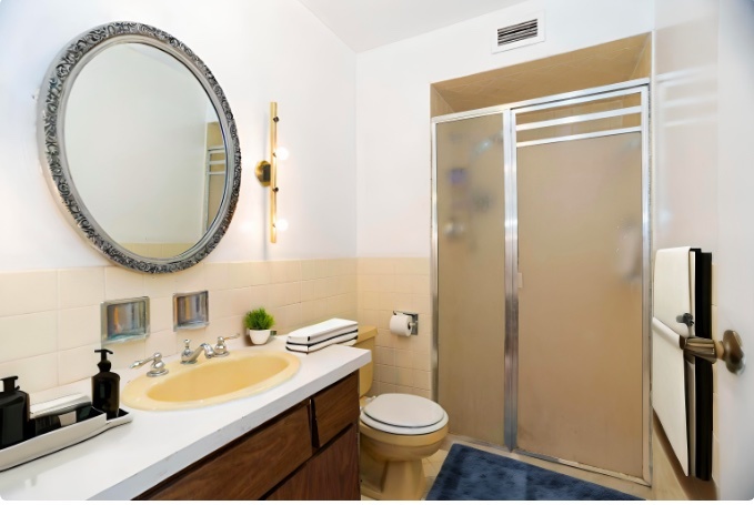 6007 North Sheridan Road, Unit 12D Chicago, IL 60660 - Photo 9 of 13 a bathroom with a sink a toilet and a mirror