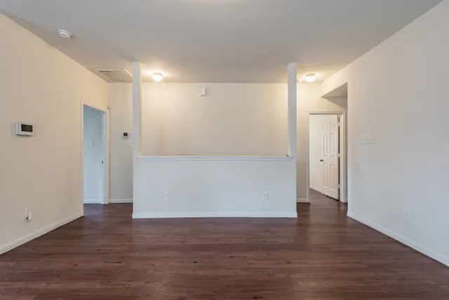 a view of empty room with wooden floor