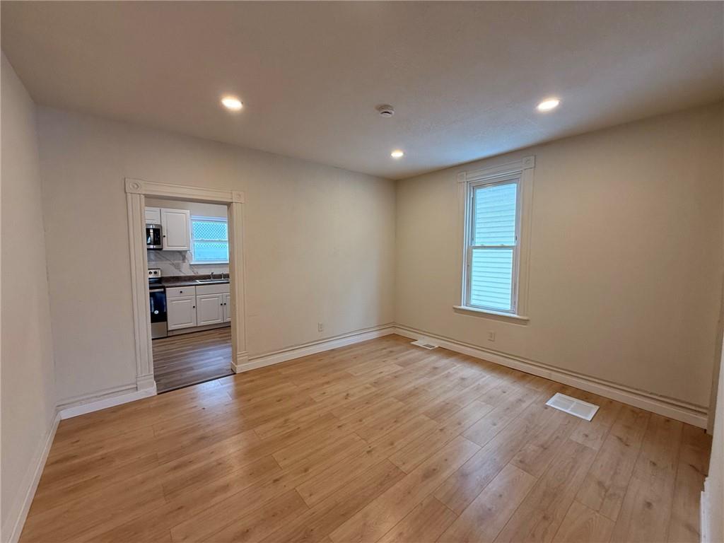828 Frank Street McKees Rocks, PA 15136 - Photo 4 of 14 a view of empty room with wooden floor and kitchen