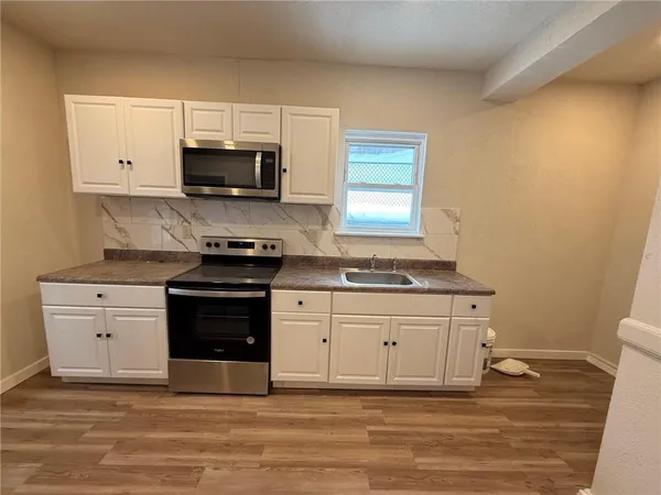 a kitchen with granite countertop a stove and a sink