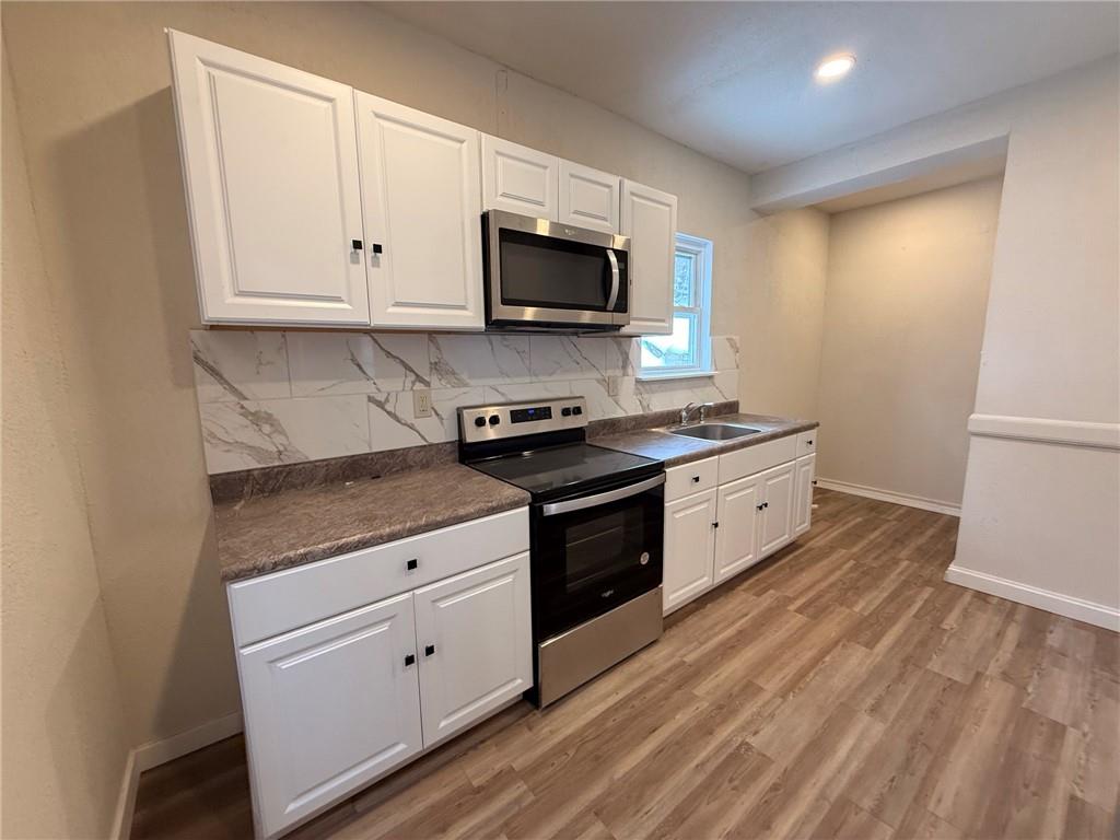 828 Frank Street McKees Rocks, PA 15136 - Photo 8 of 14 a kitchen with stainless steel appliances granite countertop a stove a sink and a microwave