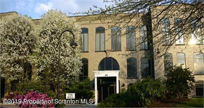 a front view of a house with a tree