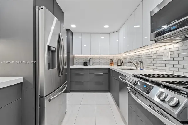 a kitchen with stainless steel appliances granite countertop a refrigerator and a stove