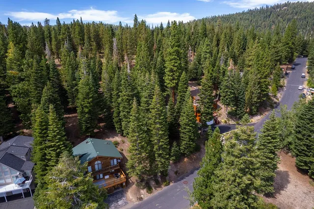 an aerial view of a city with lots of residential buildings green landscape and mountain view