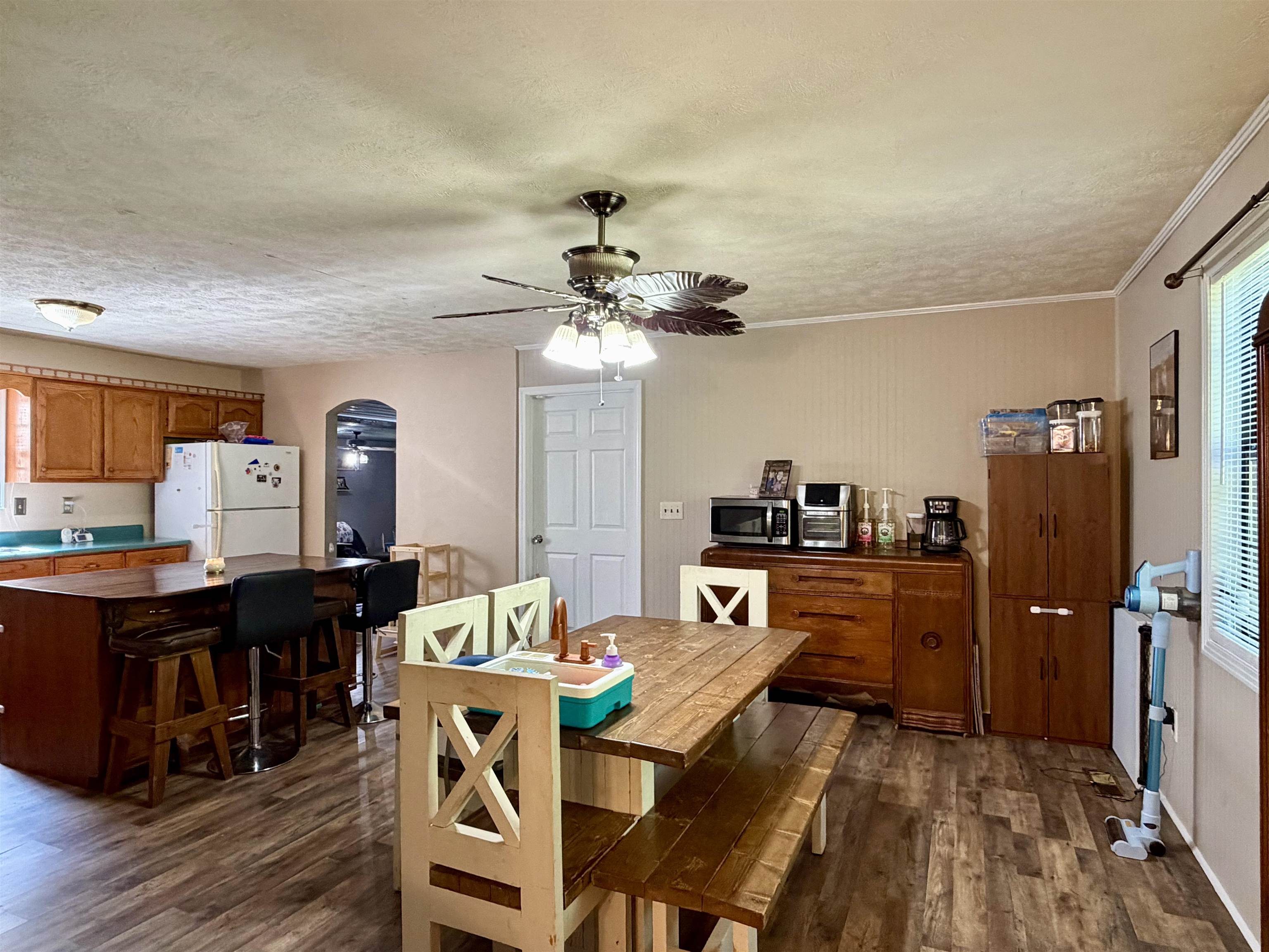 1536 Robinson Shed Road Bethel Springs, TN 38315 - Photo 11 of 23 Kitchen area featuring wood-finish flooring, a ceiling fan with integrated lighting, and an archway leading to another room