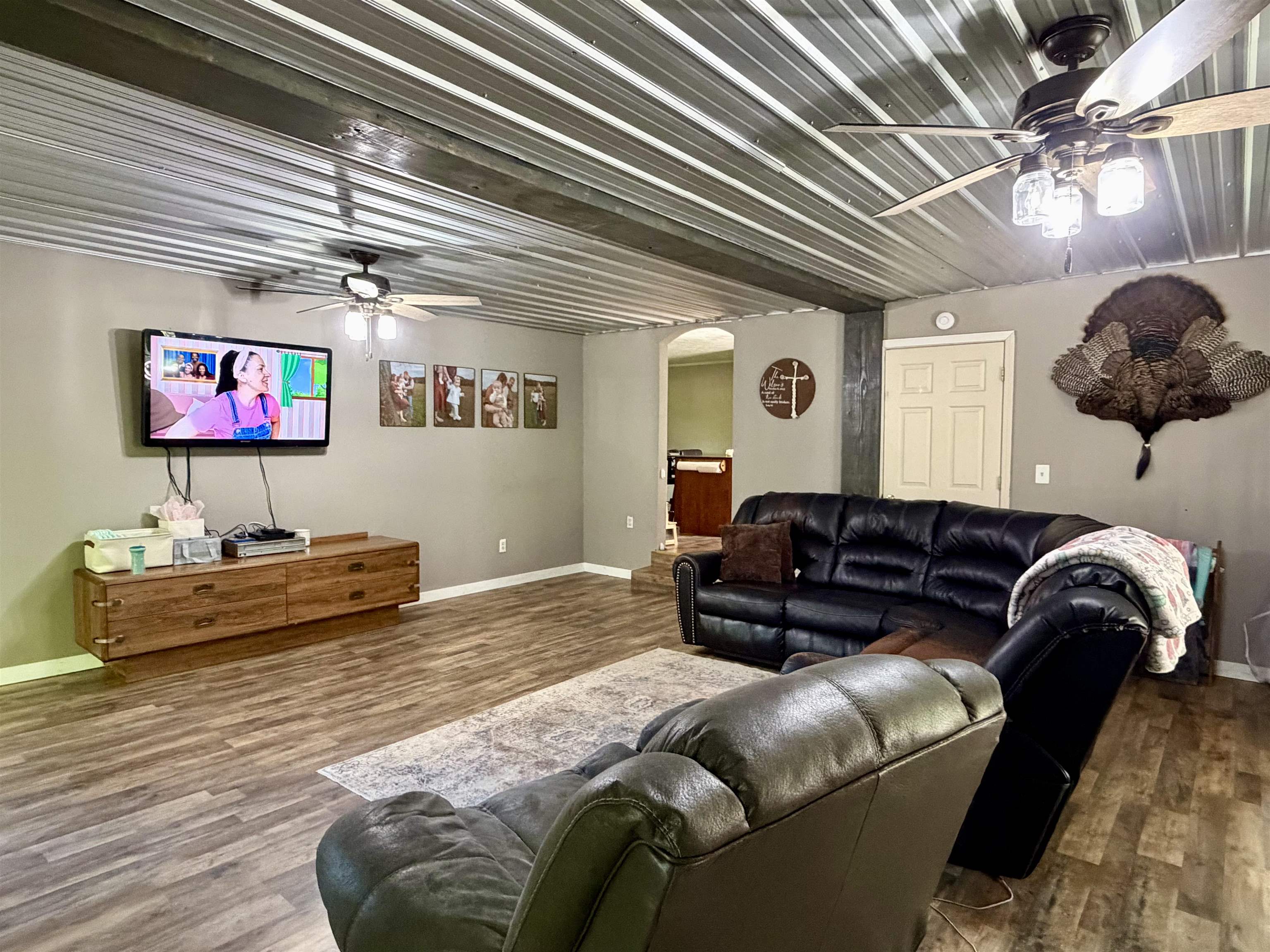 1536 Robinson Shed Road Bethel Springs, TN 38315 - Photo 3 of 23 Spacious living area featuring a corrugated metal ceiling and wood-finish flooring