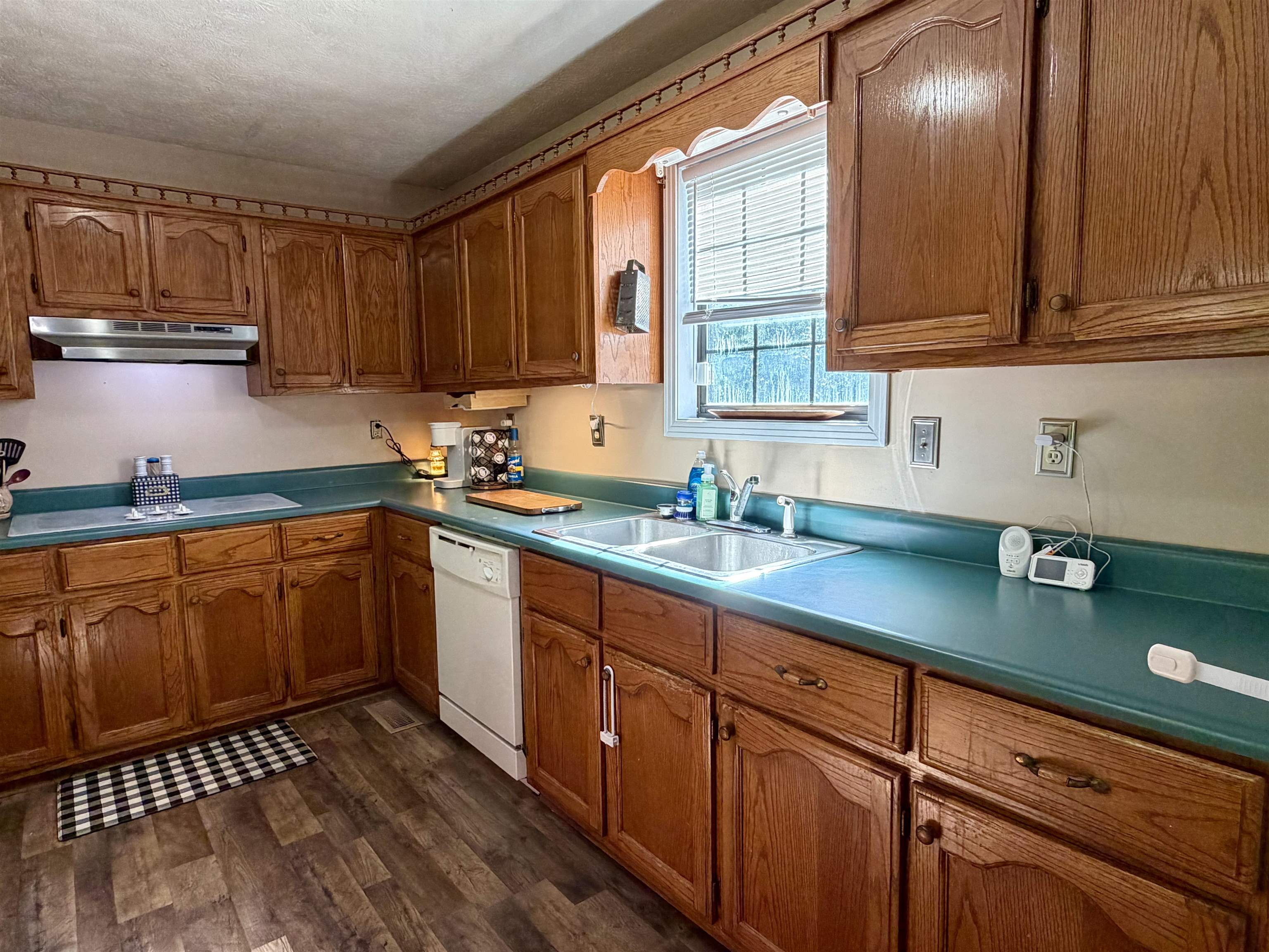 1536 Robinson Shed Road Bethel Springs, TN 38315 - Photo 6 of 23 Kitchen featuring extensive wood cabinetry with decorative arch panels, a stainless steel double basin sink, and a white dishwasher