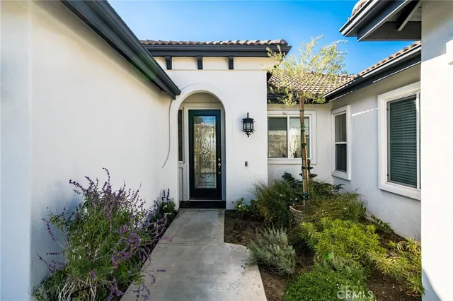 a front view of a house with a lots of flower garden