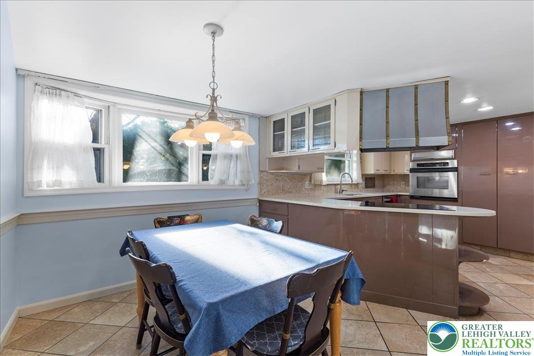 1331 Armstrong Road Bethlehem, PA 18017 - Photo 15 of 28 a kitchen with stainless steel appliances kitchen island granite countertop a table chairs in it and wooden floors