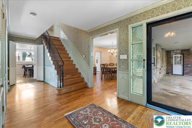 a view of a hallway with wooden floor near a dining room