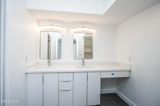 a bathroom with a double vanity sink and a mirror