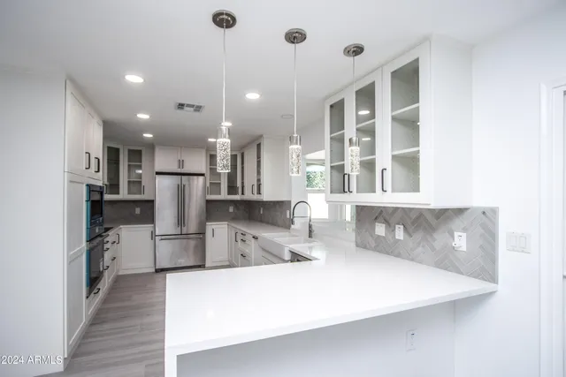 a large kitchen with stainless steel appliances a refrigerator and a stove top oven