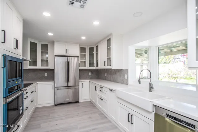 a kitchen with white cabinets and stainless steel appliances