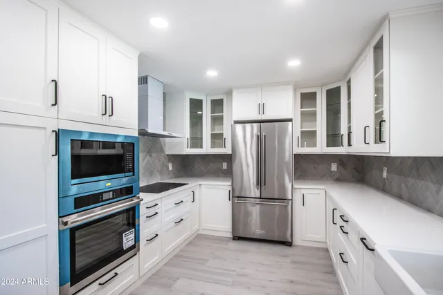 a kitchen with white cabinets and stainless steel appliances