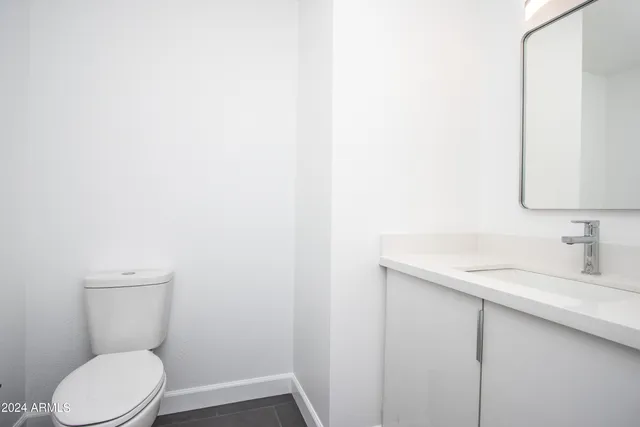 a white toilet sitting next to a bathroom sink