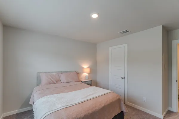 a bedroom with a bed and a night stand