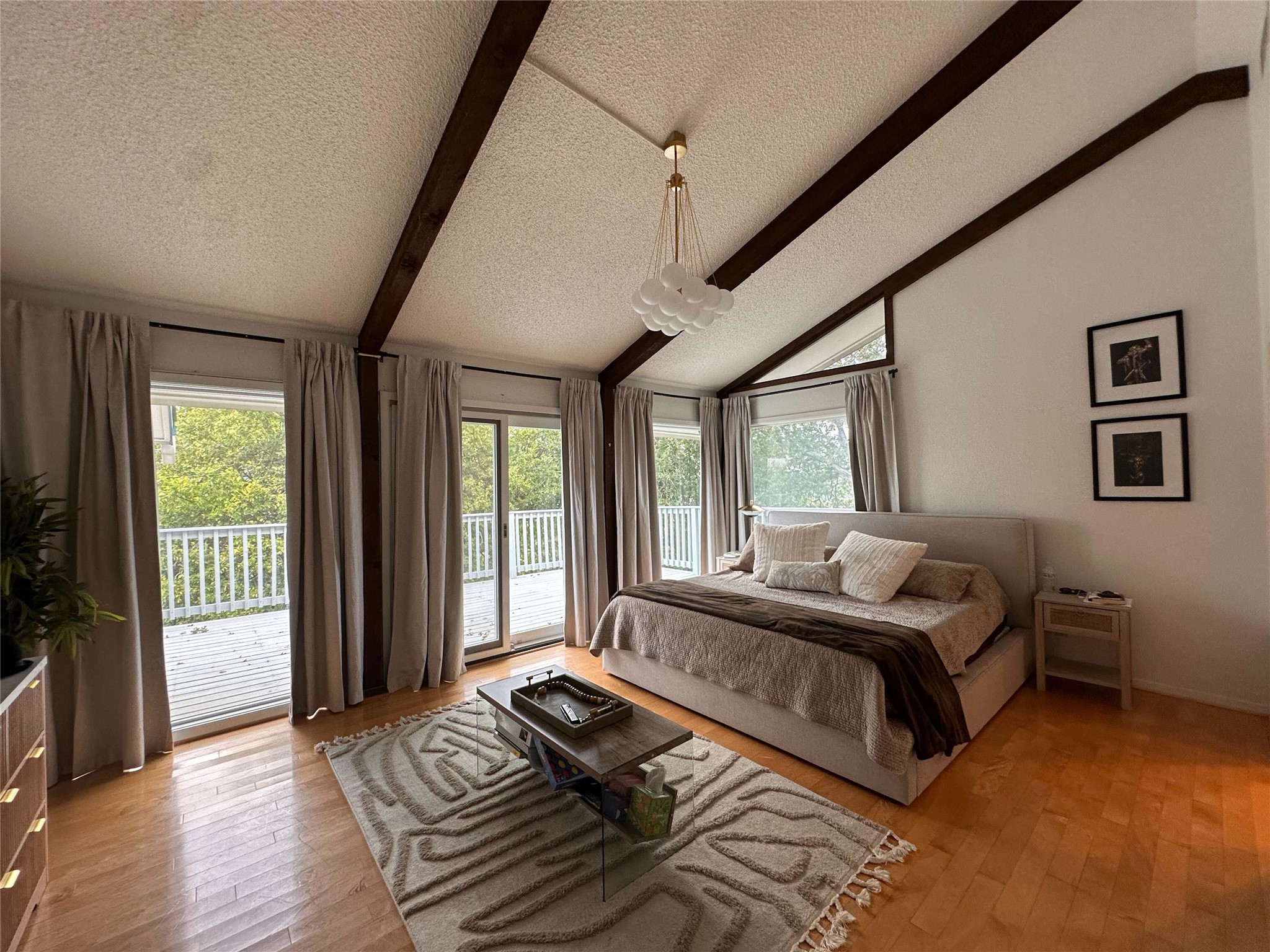 1302 Ridgecrest Drive Austin, TX 78746 - Photo 11 of 19 Exposed wood beams accentuate the vaulted ceiling of this hardwood-floored bedroom with deck access.