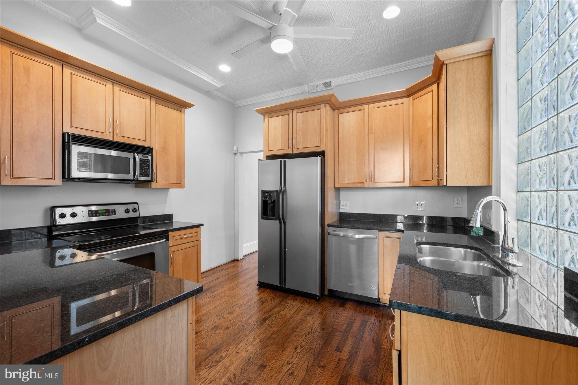 221 M Street Northwest Washington, DC 20001 - Photo 11 of 33 a kitchen with a refrigerator a stove top oven and sink