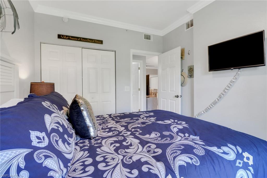 10126 Villagio Palms Way, Unit 107 Estero, FL 33928 - Photo 14 of 43 a bedroom with a bed and a flat screen tv