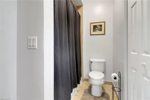 a bathroom with a toilet and a painting