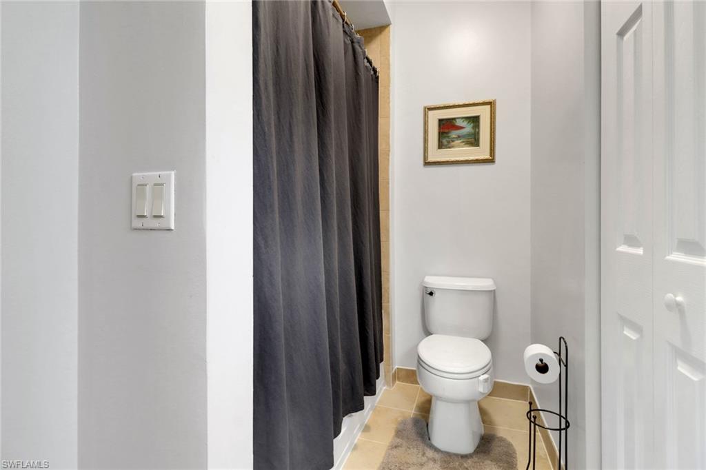10126 Villagio Palms Way, Unit 107 Estero, FL 33928 - Photo 15 of 43 a bathroom with a toilet and a painting
