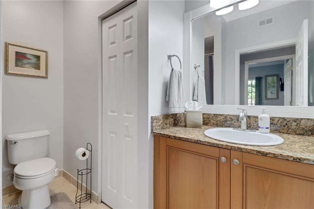 10126 Villagio Palms Way, Unit 107 Estero, FL 33928 - Photo 16 of 43 a bathroom with a granite countertop toilet sink and mirror