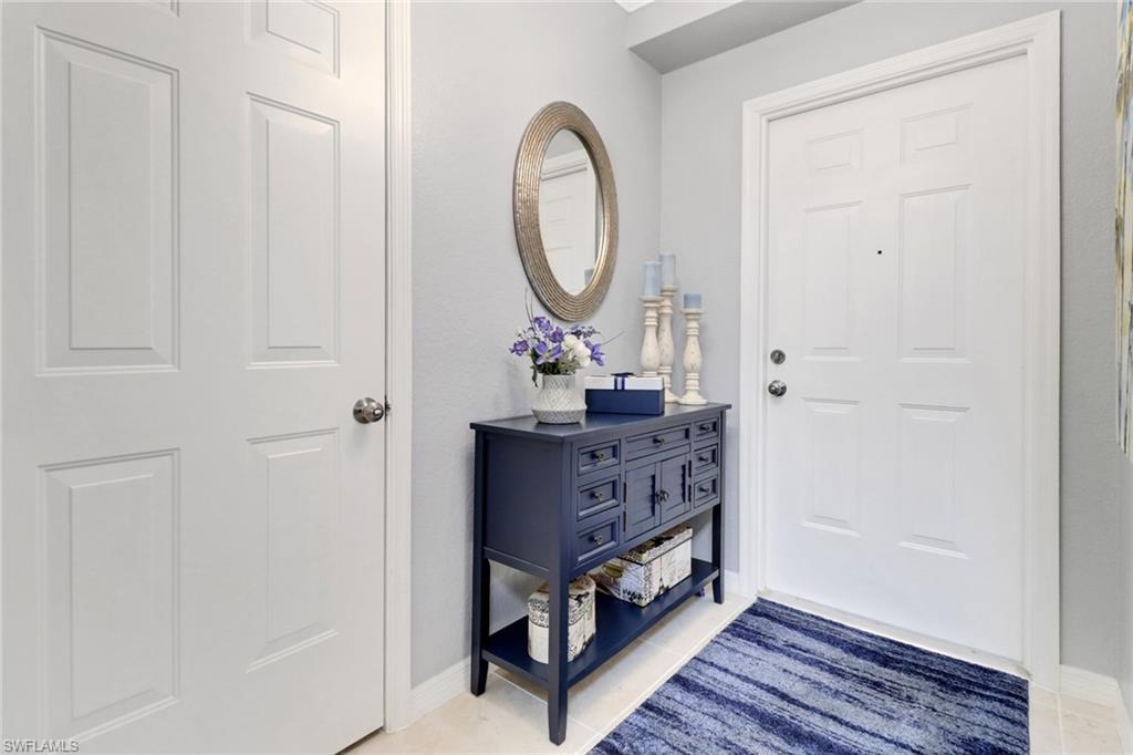 10126 Villagio Palms Way, Unit 107 Estero, FL 33928 - Photo 2 of 43 a room with a mirror and a table in it