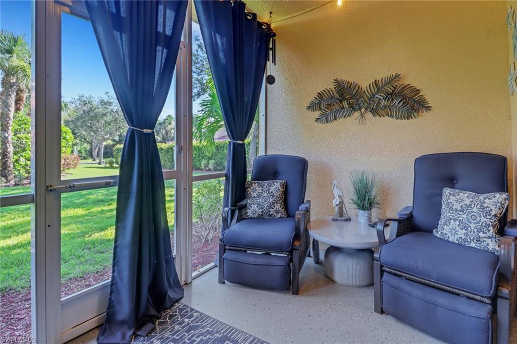 10126 Villagio Palms Way, Unit 107 Estero, FL 33928 - Photo 24 of 43 a living room with furniture and a large window
