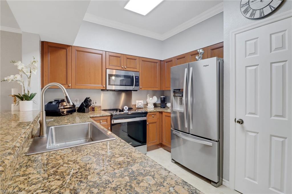 10126 Villagio Palms Way, Unit 107 Estero, FL 33928 - Photo 3 of 43 a kitchen with granite countertop a refrigerator stove and sink