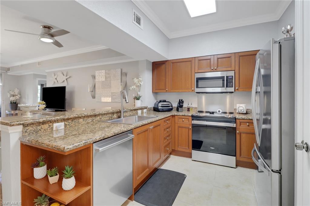 10126 Villagio Palms Way, Unit 107 Estero, FL 33928 - Photo 4 of 43 a kitchen with stainless steel appliances granite countertop a sink stove and microwave